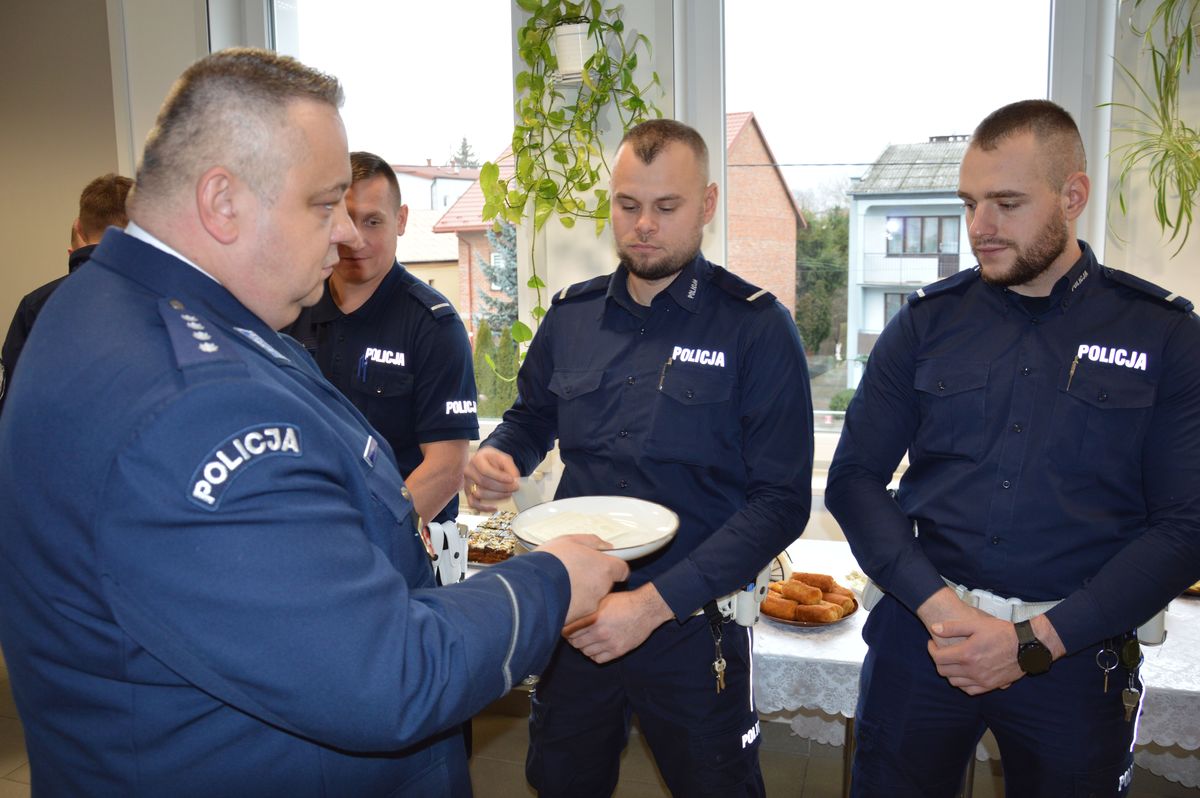 Policjanci podczas spotkania wigilijnego dzielą się opłatkiem