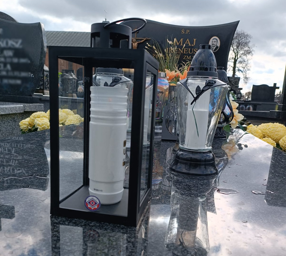 Znicz zapalony z logiem pionu ruchu drogowego postawiony na grobie zmarłego policjanta