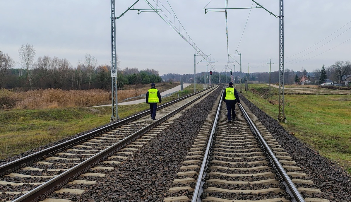 Funkcjonariusze policji  i straży ochrony kolei patrolują i sprawdzają teren linii kolejowej.