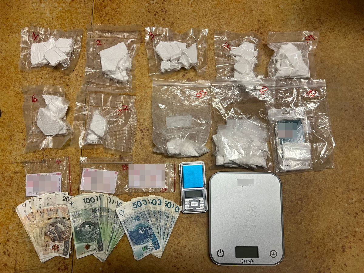 Zabezpieczone narkotyki zapakowane w woreczki, wagi elektroniczne, pieniądze ułożone na podłodze