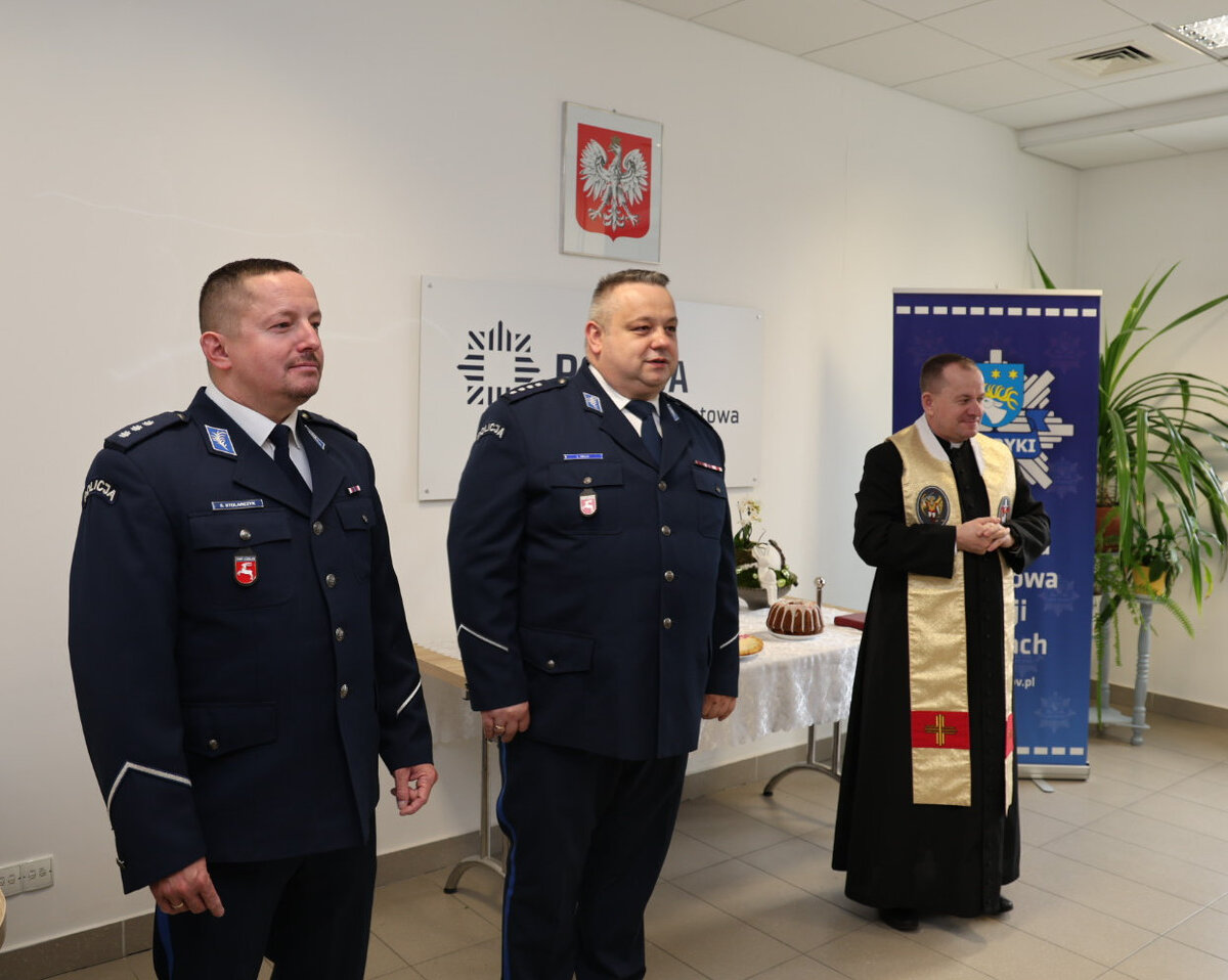 Komendant Powiatowy Policji w Rykach jego zastępca oraz ksiądz kapelan stoją na sali odpraw