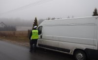 Policjant kontrolujący samochód typu bus.