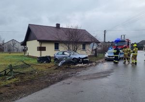 Kolizja drogowa w Grabowie Szlacheckim - na zdjęciu widoczny jest uszkodzony samochód osobowy marki Audi oraz ogrodzenie posesji i znak drogowy.