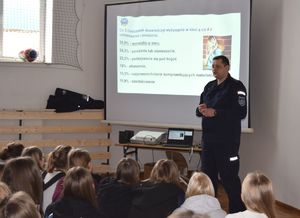 Zdjęcie przedstawia uczestników spotkania policjanta z Komendy Powiatowej Policji w Rykach oraz dzieci z Szkoły Podstawowej w Kłoczewie