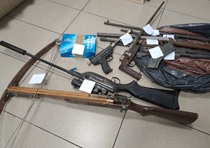 Zdjęcia przedstawia zabezpieczona broń palną i amunicje oraz kuszę położoną na podłodze