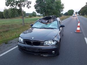 Zdjęcie przedstawia uszkodzony samochód maiki BMW koloru ciemnego z uszkodzeniami powstałymi w wyniku zderzenia z łosiem.