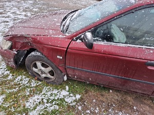 Uszkodzony samochód osobowy koloru bordowego. Uszkodzony jest lewy przedni bok.