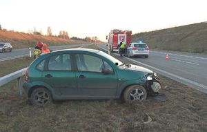 Uszkodzony samochód osobowy marki Citroen koloru zielonego stojący na pasie zielenie trasy S17 . W tle widoczna jezdnia drogi.