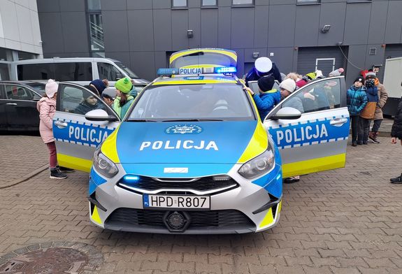 Zdjęcie przedstawiają uczniów,  i nauczycieli szkoły podstawowej w Nowej Rokitni podczas zwiedzania Komendy Powiatowej Policji w Rykach. Dzieci oglądają oznakowany radiowóz.