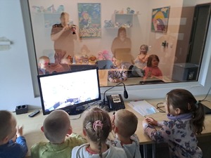Grupa kilkunastu dzieci podczas zwiedzania budynku Komendy Powiatowej Policji w Rykach - pokój przesłuchań dzieci