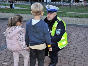 policjant rozmawia z dziećmi na ulicy