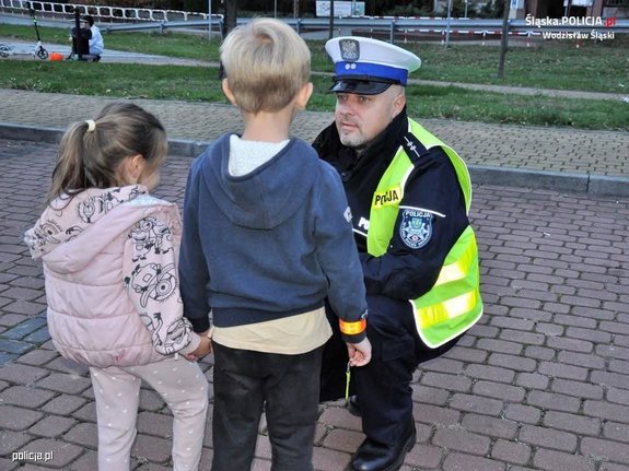 policjant rozmawia z dziećmi na ulicy