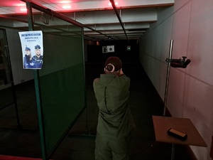 Zwiedzająca dziewczyna  na strzelnicy sprawdza celownik laserowy
