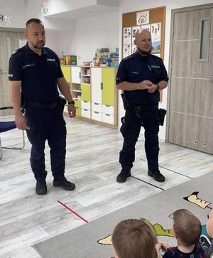 fotografia ze spotkani policjantów z przedszkolakami. Policjanci stoją przed grupa dzieci