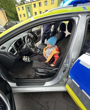 fotografia ze spotkani policjantów z przedszkolakami. Dziecko siedzące w radiowozie