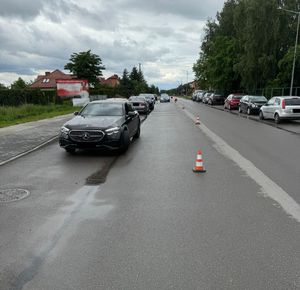Zdjęcia ze zdarzenia drogowego wzdłuż drogi stają zaparkowane pojazdy na środku jezdni  są ustawione pachołki