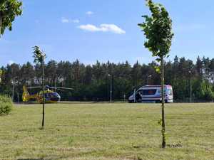 śmigłowiec pogotowia ratunkowego który wylądował na trawie obok stoi karetka pogotowia