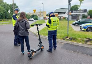 policjanci kontrolują kierującą hulajnogą elektryczną