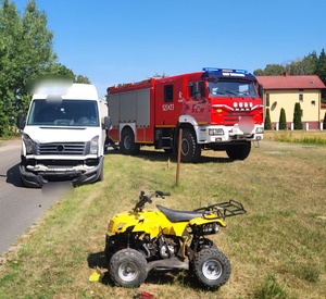 zdjęcie z miejsca wypadku drogowego widoczny jest quad koloru żółtego oraz bus koloru białego w tle wóz bojowy straży pożarnej i śmigłowiec pogotowia ratunkowego