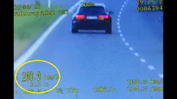 Stop klatka z wideorejestratora na której widać jak auto osobowe jedzie z prędkością ponad 200 kilometrów na godzinę.