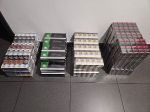 Zabezpieczone paczki papierosów ułożone w 4 stosach na podłodze.