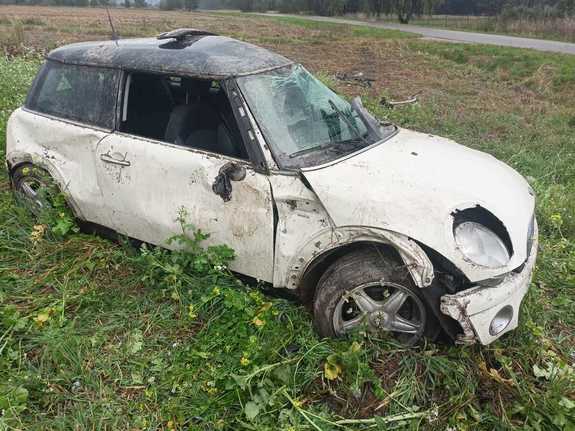 Samochód marki Mini koloru białego uszkodzony po dachowaniu stojący na polu uprawnycm