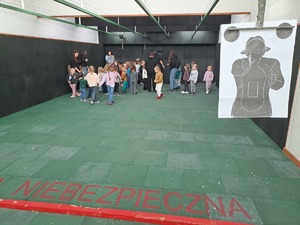 Grupa przedszkolaków zwiedza obiekt Komendy Powiatowej Policji w Rykach i zapoznaje się ze sprzętem