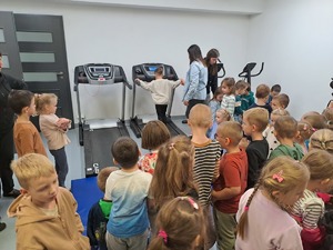 Grupa przedszkolaków zwiedza obiekt Komendy Powiatowej Policji w Rykach i zapoznaje się ze sprzętem