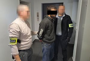 Zatrzymany mężczyzna o dokonanie przestępstwa prowadzony przez dwóch nieumundurowanych policjantów