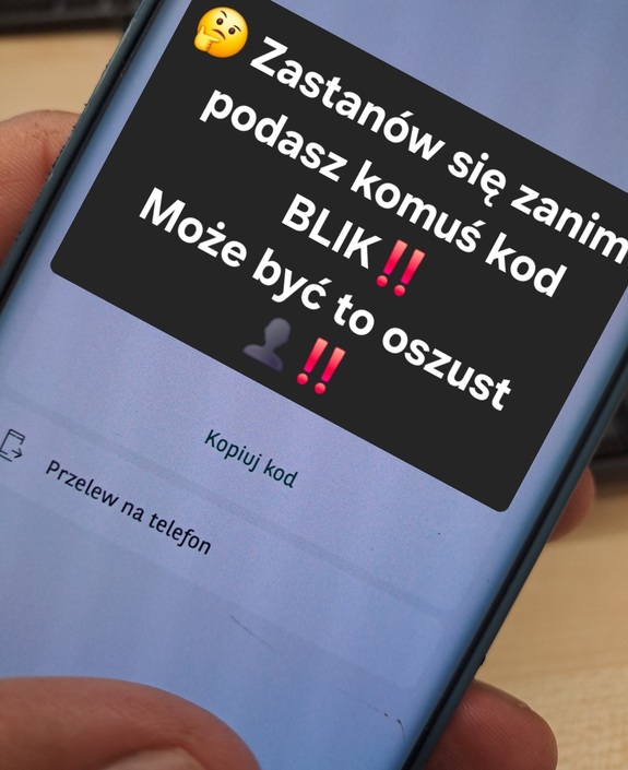 Telefon trzymany w dłoni z napisem na wyświetlaczu Zastanów się zanim podasz komuś kod Blik Może być to oszust!