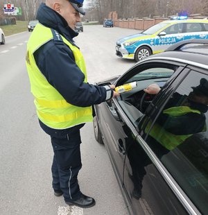 Policjant podczas badania stanu trzeźwości kierowcy na drodze