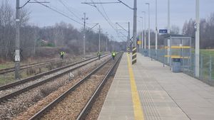funkcjonariusze oraz żołnierz wojsk obrony terytorialnej sprawdzają torowisko kolejowe i rejon peronu .