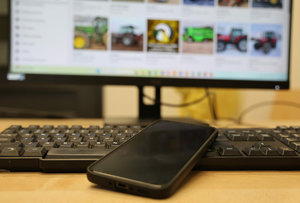 Zdjęcie klawiatury, telefonu i ekranu komputera z rozmazanym ekranem