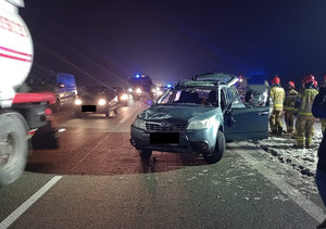 Miejsce zdarzenia drogowego na trasie S17 widoczne uszkodzony w wyniku zdarzenia samochód osobowy, pojazdy służb oraz inne pojazdy poruszające się drogą oraz służby ratunkowe - strażacy i osoby uczestniczące