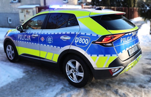 radiowóz policji oznakowany marki KIA w tle zbudowa miejska