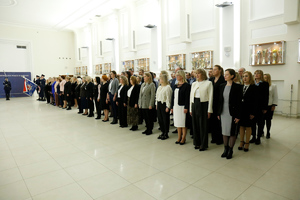 Grupa wyróżnionych pracowników służby cywilnej podczas uroczystości stojący na sali konferencyjnej.