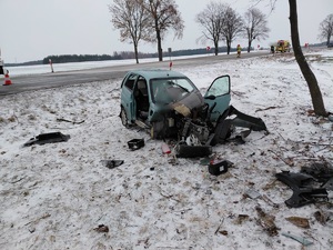 Pojazd uszkodzony w wyniku zdarzania drogowego w tle jednia i pojazdy służb ratunkowych