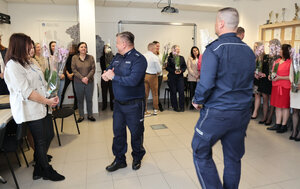 Uczestnicy spotkani z okazji dnia kobiet w sali odpraw ryckiej komendy kobiety otrzymują kwiaty