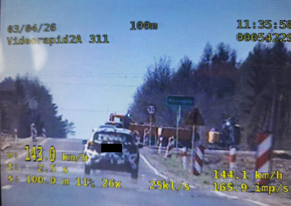 ekran wideo rejestratora na którym widać pojazd osobowy, któremu zmierzono prędkość oraz w tle droga znaki drogowe i inne pojazdy, na dole wyświetlone są parametry urządzenia pomiarowego w tym wynik pomiaru 143 kh/h