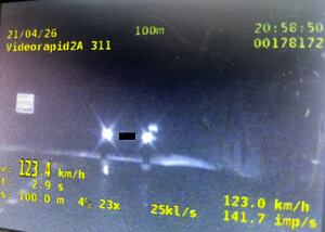 ekran monitora wideorejstratora z zarejestrowanym pomiarem prędkości w porze nocnej widoczne światła pojazdu oraz parametry pracy urządzenia w tym wynik pomiar 123,4 km/h
