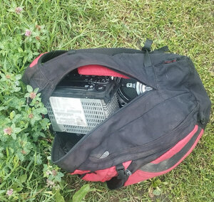 Torba materiałowa częściowo otwarta i wewnątrz widoczne są radio samochodowe i głośniki