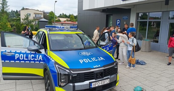 Młodzież w raz z opiekunami z Specjalnego Ośrodka Szkolno-Wychowawczego zwiedza Komendę Powiatową Policji w Rykach oglądają radiowóz policyjny