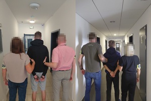 Kolarz dwóch zdjęć na których. Zatrzymani mężczyźni  mają założone kajdanki na ręce trzymane z tyłu i są trzymani przez policjanta i policjantkę z opaskami z napisem policja.