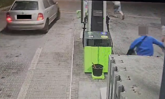 Skoda na stacji paliw obok na stanowiskach po drugiej stronie biegnie 3 mężczyzn