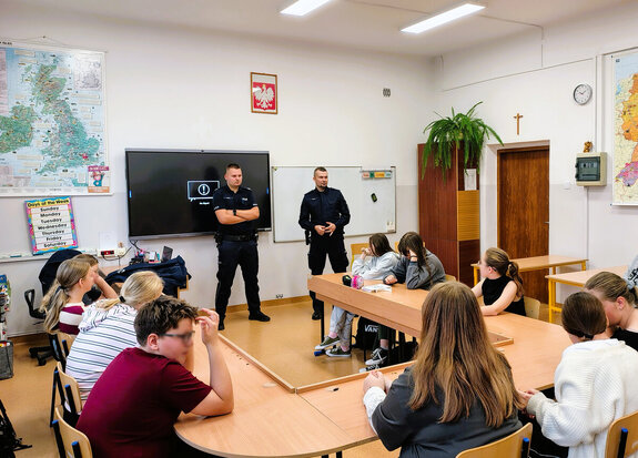 Policjanci prowadza spotkanie z uczniami szkoły w sali lekcyjnej