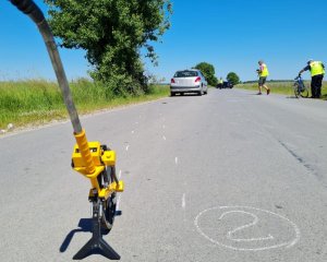 policyjny &quot;kołowrotek&quot; , w tle rozbity pojazd i policjanci